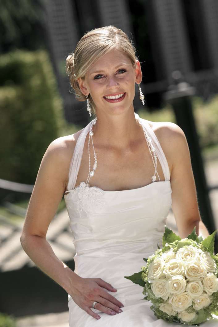 Eine hübsche blonde Braut schaut in die Kamera